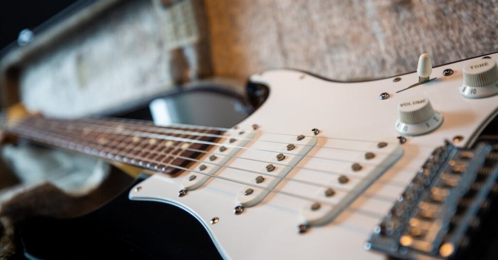 不要になったギターを売却しようか迷う男性がギターを見つめる様子