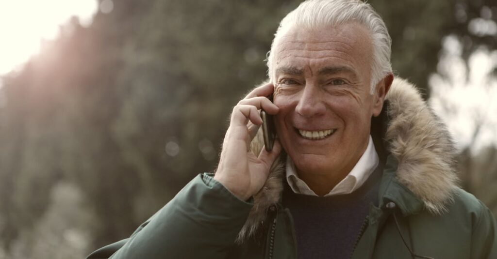 シニア世代がスマートフォン料金を格安SIMで節約し、満足そうにスマホを操作している様子