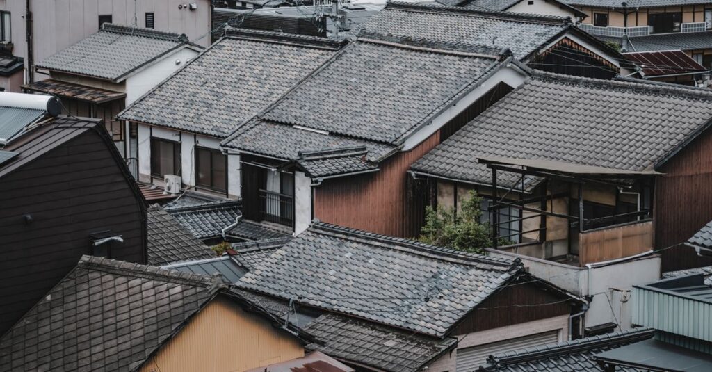 岡山県の住宅が地元業者によって美しく塗装され、家主が満足して微笑んでいる様子。地域密着の信頼を表現した写真。
