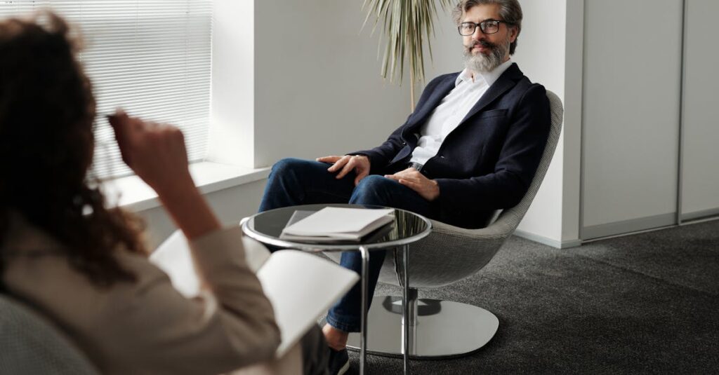 職場で英語を使う社会人のビジネスシーン。会議中に英語で発言する姿が印象的な一枚。