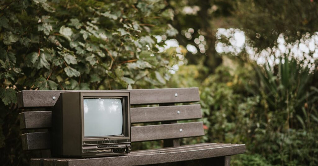 中古サックスの買取価格を確認する男性の後ろ姿。机には楽器と書類が並ぶ。