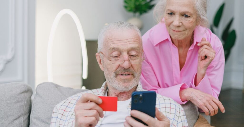 シニア世代がスマートフォン料金を格安SIMで節約し、満足そうにスマホを操作している様子