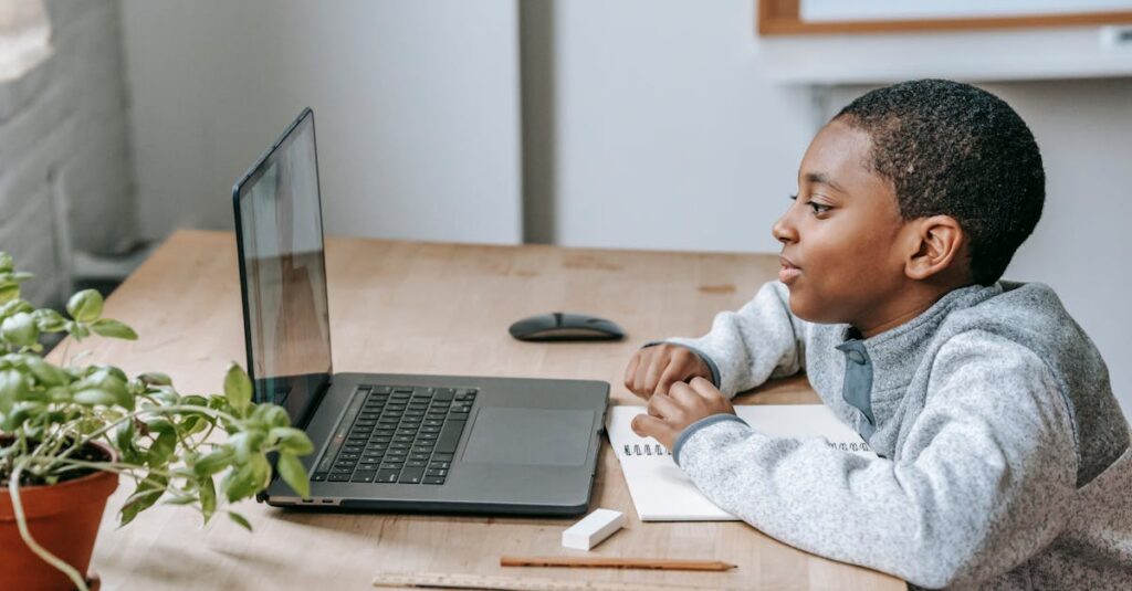 子どもが遊んでいる間にパソコンで通信講座を受ける母親の様子